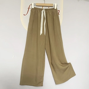 Detail of elastic waist and white ribbon drawstring on khaki wide-leg pajama pants