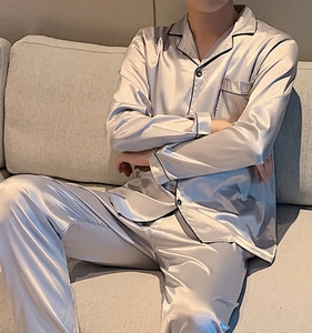 Close-up of silver-grey satin pajamas with black piping and premium silk texture