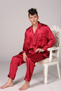 Macro detail of wine red satin pajama set showing white piping and smooth silk-like fabric
