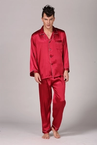 Detail of burgundy satin pajama set featuring white piping and high-gloss silk texture