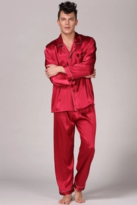 Detail of dark red satin men's pajamas set featuring white piping and chest pocket