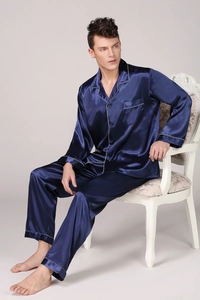 Detail of dark blue satin pajamas showing silky texture and white contrast piping on lapel
