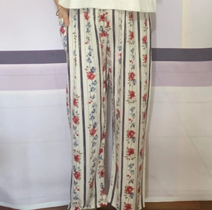 Detail of floral striped wide-leg trousers showing functional side pocket and soft fabric