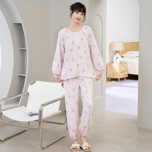 Detailweergave van de roze pyjama met lange mouwen, kersentextuur en elastische manchetten