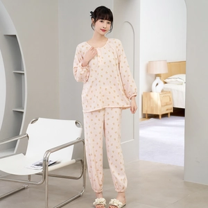 Detail van de roze katoenen pyjamaset met berenprint, knoopsluiting en elastische manchetten