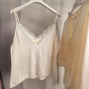 Détail d'un caraco en satin crème avec broderie de dentelle délicate au décolleté