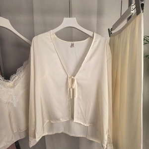 Détail de l'ensemble de pyjama en soie crème avec bordure en dentelle et ruban noué
