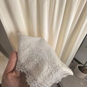 Détail en satin ivoire élégant avec bordure en dentelle florale délicate et texture lisse