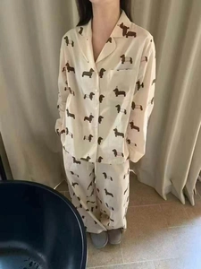 Detail eines cremefarbenen Langarm-Pyjamas mit Dackel-Print und Knopfleiste