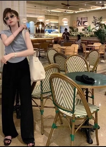 Relaxed fit high-waisted black wide-leg trousers styled in a casual cafe setting