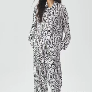 Details des dünnen Eisseiden-Pyjama-Sets mit schwarz-weißem Wellenmuster und Reverskragen