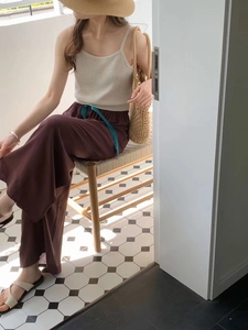 Detail of loose wide-leg pajama pants with a blue drawstring and drape texture