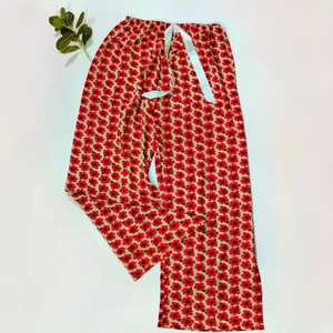 Detailed flat lay of long floral pajama pants featuring red flowers and a satin drawstring