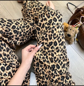 Detail of leopard print wide-leg pajama pants with silky texture and draped fit