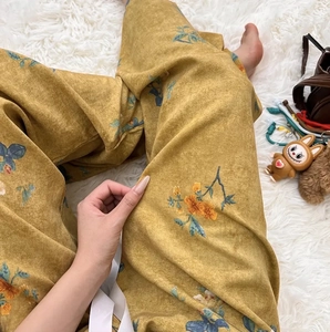 Macro view of yellow floral wide-leg lounge pants with white waist drawstring detail