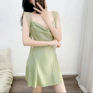 Detail showing the light green satin dress with elegant drape neck and silky texture