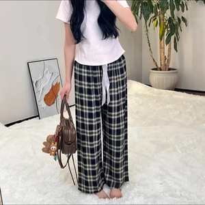 Detailed view of women's black and white plaid wide-leg pajama pants with silk drawstring