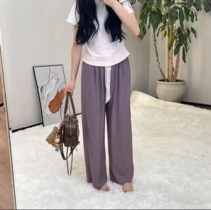 Detail of loose dark purple wide-leg pajama pants with high waist and white drawstring