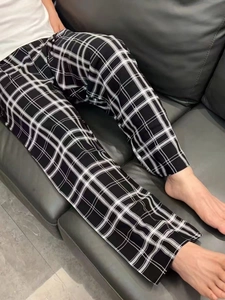 Classic black and white checkered loungewear pants with drawstring waist on a sofa