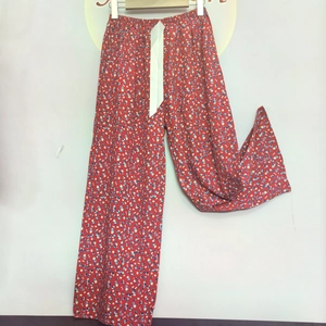 Detail of red floral cotton lounge pants with elastic waist and white satin ribbon tie