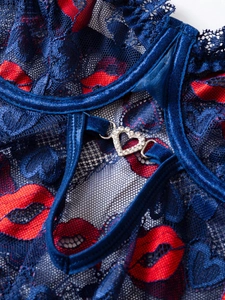 Macro detail of blue floral lace lingerie featuring red lip prints and a heart rhinestone buckle