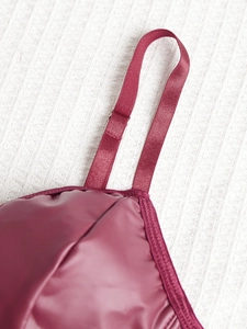 Detail of burgundy camisole with shiny fabric and adjustable metal strap buckle