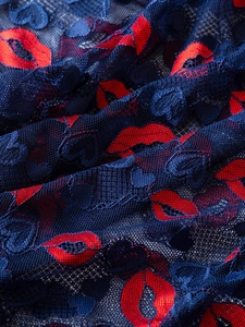 Detail of navy lace fabric with red lip and heart patterns for Valentines lingerie