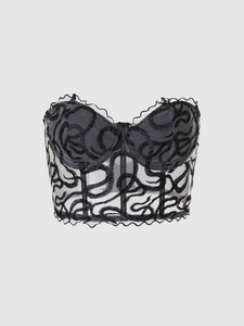 Detailed view of black floral embroidery and bone structure on sheer mesh corset top