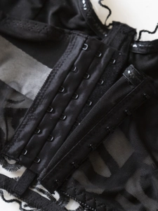 Close-up of the three-row hook and eye closure on black lace strapless bustier