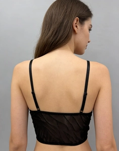 Detail of adjustable straps and semi-sheer lace fabric on this black gothic corset top