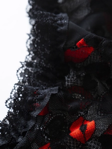 Macro shot of black lace fabric with red floral embroidery for sexy lingerie detail