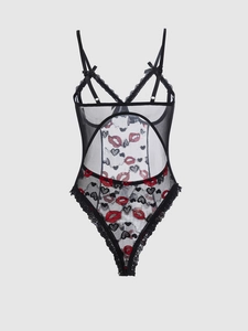 Detailed view of sheer black lace bodysuit with heart patterns and circular cut-outs
