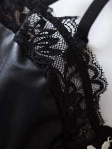 Detail von schwarzer Blumenspitze und strukturierter PU-Leder-Naht an einem Bodysuit