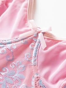 Detail of pink mesh bodysuit with light blue floral lace embroidery and satin bow