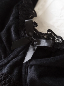 Détail de lingerie en velours noir avec dentelle délicate et nœud en satin