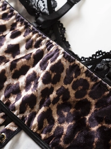 Detail of leopard print fabric with black lace trim and adjustable metal straps