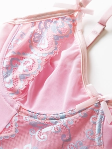Detail of pink mesh bodysuit with light blue floral lace and sweet bow accents