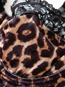 Close-up of leopard print velvet fabric with intricate black lace trim detailing