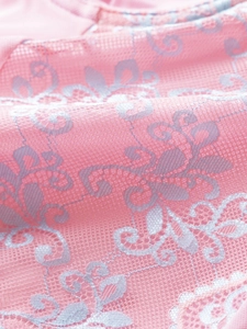 Macro detail of delicate floral lace fabric with blue embroidery and sheer mesh texture