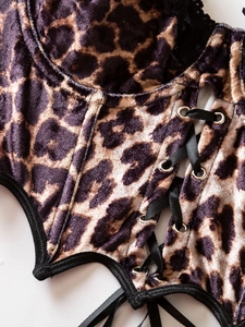 Detail of leopard print velvet corset with lace trim and black lace-up ribbon design