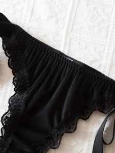 Vue détaillée des coutures en dentelle noire et du tissu plissé sur cette culotte sexy