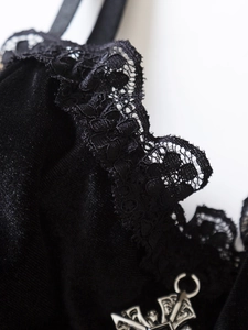 Dettaglio macro di lingerie in velluto nero con pizzo floreale e gancio in metallo lucido