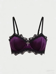 Detail of dark purple velvet bra with black lace trim and silver cross pendant accessory