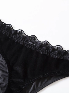 Dettaglio di intimo in velluto nero con bordi in pizzo floreale e ricami raffinati