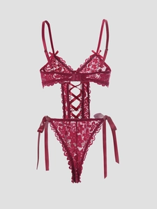 Detail of red floral lace teddy with satin bows and criss-cross strappy cutouts