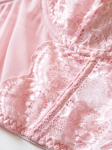 Close-up of pink lace floral embroidery and soft mesh fabric texture on the bodice