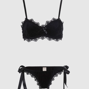 Detail of black velvet lingerie set with eyelash lace trim and satin side-tie panties