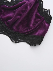 Detail of dark purple velvet fabric and intricate black lace trim on the bra cups