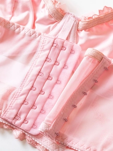 Close-up of pink mesh corset back featuring four-row hook-and-eye closure and lace trim