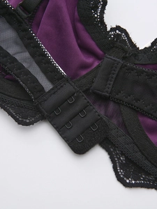 Detail view of the back closure featuring 3-row hooks and black lace on purple velvet bra